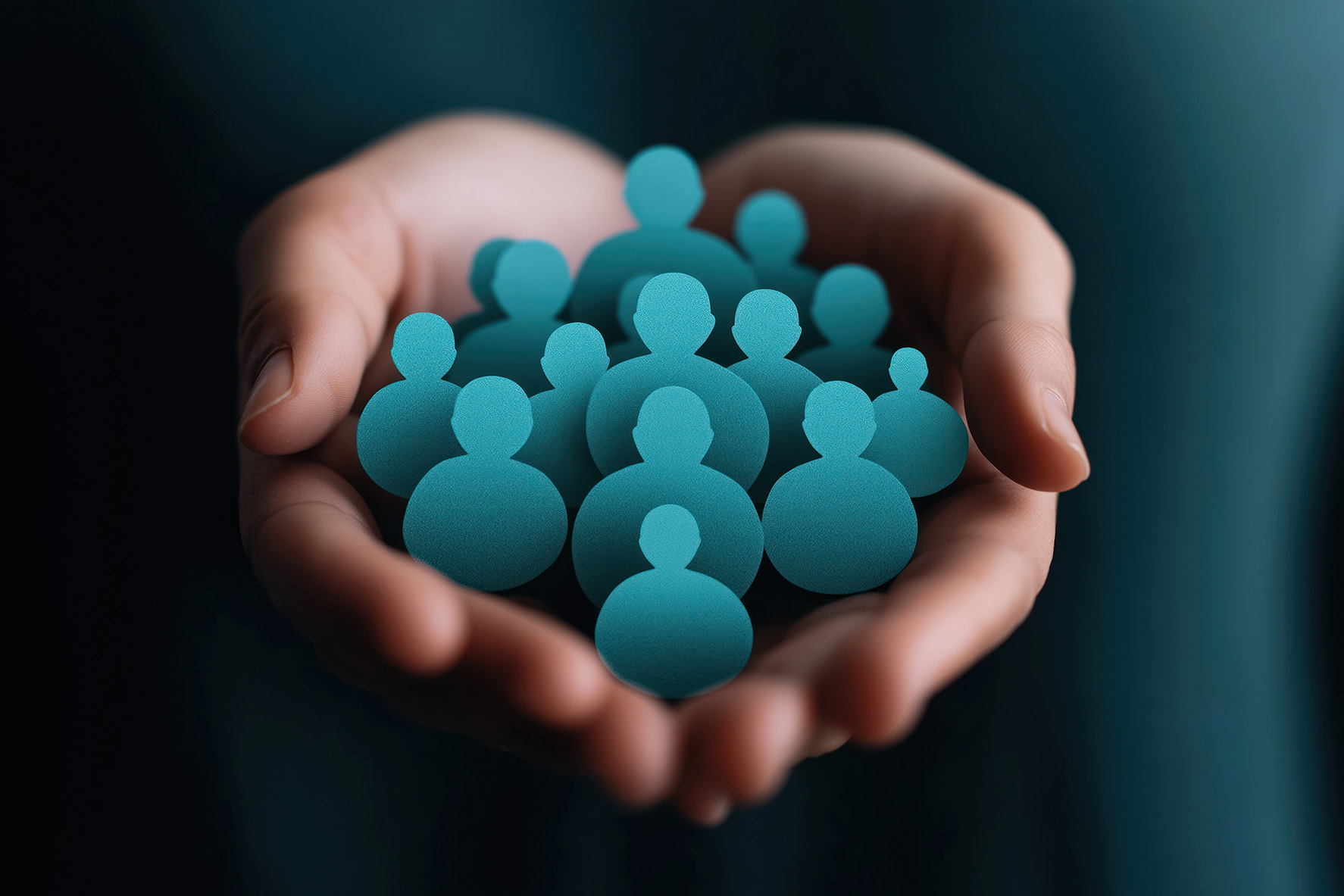 Loyalty Core Values Pair of hands holding teal silhouette icons of people, which represents one of Emerald's core values: loyalty
